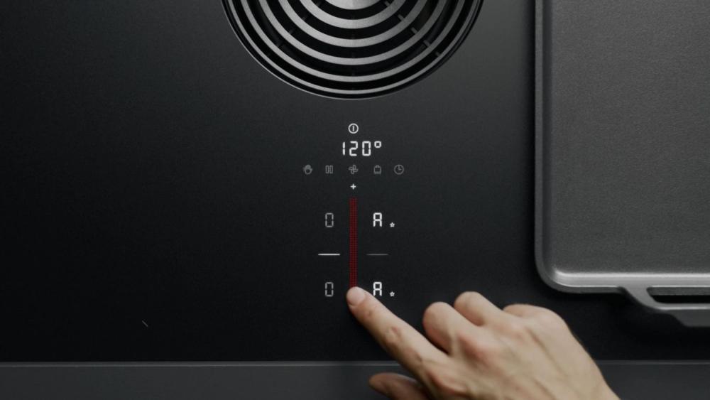 Едър кадър на sControl+ сензорния плъзгач на BORA S Pure с трицветно осветление, вграден дискретно в черната стъклокерамика.